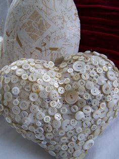 two heart shaped vases sitting on top of a white cloth covered table next to each other