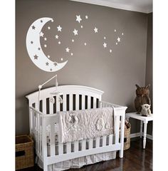 a baby's room with a white crib and stars on the wall