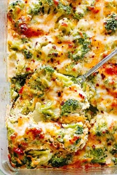 broccoli and cheese casserole in a glass dish with a spatula