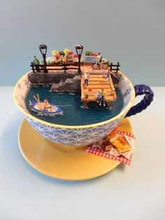 a teacup with a miniature boat in it on top of a saucer that is sitting on a plate