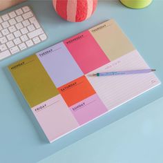 a notepad sitting on top of a desk next to a keyboard