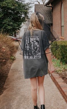 a woman walking down a sidewalk with her back to the camera, wearing a t - shirt that says i heard you are pretty