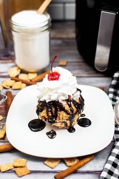 a piece of cake with whipped cream and cherries on top is sitting on a plate