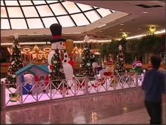 an indoor christmas display with snowmen and trees in the background at a shopping mall