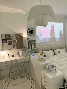 a bedroom with a bed, desk and projector screen in the corner on the wall