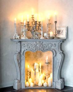 a mantel with candles and pictures on it