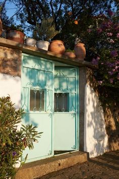 a blue door with pots on top of it