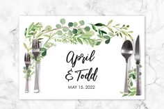 the wedding place card is decorated with greenery and silverware, along with two forks