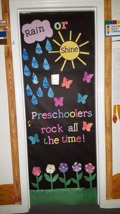 a bulletin board with rain, sun and flowers on it in front of a classroom door