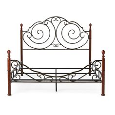 a metal bed frame with wooden posts and scroll designs on the headboard, against a white background