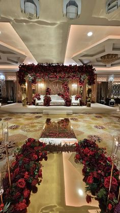 an elaborately decorated room with red flowers on the floor and candles in front of it