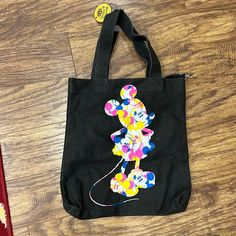 Canvas Disney Tote Black With Blue, Yellow, Pink And White 16.5 X 14.5 Inches 3 Inside Small Pockets Clip To Attach Smaller Bag/Wallet/Etc Nwt Disney Black School Bags, Disney Style Black School Bags, Black Mickey Mouse Bag For Disney Fan Events, Black Minnie Mouse Bag For Everyday Use, Trendy Black Minnie Mouse Bag, Mickey Mouse Tote Bags For Daily Use, Multicolor School Bag With Mickey Mouse, Multicolor Mickey Mouse Bag For Disney Trips, Multicolor Disney Bag With Mickey Mouse Design