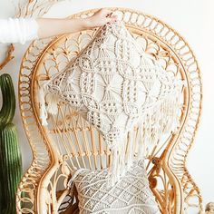 a person holding up a white crocheted chair