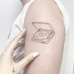 a woman's arm with a record player tattoo on the left side of her body