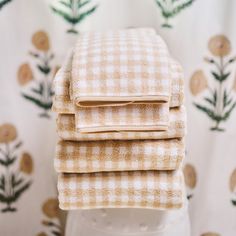 three towels stacked on top of each other in front of a wallpapered background