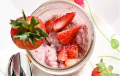 a jar filled with fruit sitting on top of a table next to a fork and knife