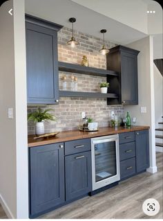 a kitchen with gray cabinets and wooden counter tops, along with an open staircase leading up to the second floor