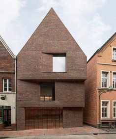 the house is made out of bricks and has a triangular shape on it's side