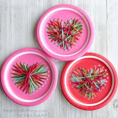 three pink plates with string art on them