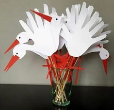 some white paper birds are in a vase with straws and toothpicks on the table