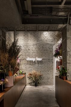 an empty room with plants and flowers on the walls, along with a sign that reads drop bar