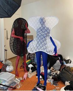 two mannequins are standing in a messy room