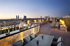 an outdoor dining area overlooking the city at dusk