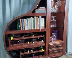 a wooden bookcase filled with lots of books and wine glasses on top of it