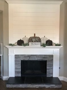 the fireplace is decorated with pumpkins and greenery