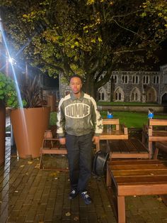 a man is standing in front of some benches and tables with the word home on it