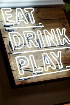 a neon sign that reads eat drink play