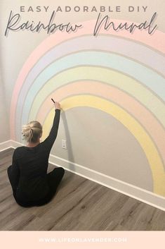 a woman is sitting on the floor and painting a rainbow wall mural with words that read easy, adorable diy rainbow murals