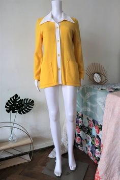 Preppy Swedish Vintage blazer/cardigan from the late 1960s or early 1970s. Made from a soft jersey fabric in yellow with white details, slightly fitted cut. Large contrasting collar, button tab and beautiful large button. Two front pockets, unlined. Looks great combined with a pair of flare jeans and clogs/mules. BRAND: Petri Swedish Design ERA: 1960s, 1970s COLOR: Yellow, white Fabric: Neospun jersey SIZE: Vintage size 38, fits best a modern size S - please check the measurements below for refe Retro Long Sleeve Cardigan For Work, White Fitted Retro Cardigan, Vintage Spring Cardigan For Workwear, Retro Yellow Cardigan For Spring, Yellow Retro Cardigan For Spring, Classic Yellow Long Sleeve Cardigan, Yellow Long Sleeve Cardigan For Work, Yellow Fitted Vintage Cardigan, Fitted Vintage Yellow Cardigan