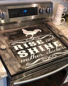 a stove top with the words rise and shine written on it in white lettering next to a coffee mug