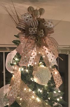 a christmas tree decorated with gold and white ribbons