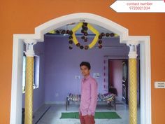 a man standing in the doorway of a room with purple walls and yellow trimmings