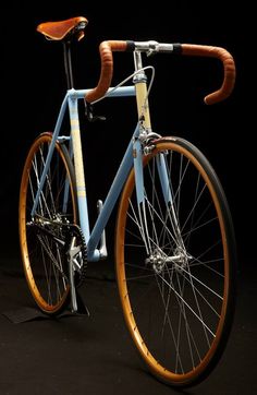 a blue bicycle with wooden spokes on it