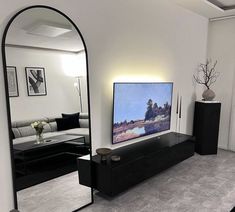 a large flat screen tv sitting on top of a wooden stand in a living room