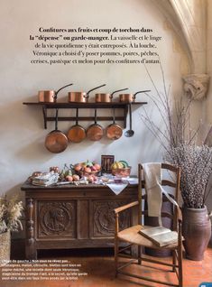 a table with pots and pans on it in front of a wall mounted shelf