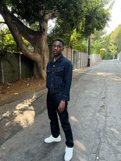 a man standing in the middle of an empty street with his hands in his pockets