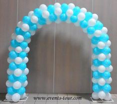 a blue and white arch with balloons on it