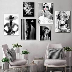 black and white photos hang on the wall above two chairs in front of a table