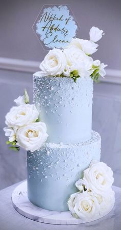 a wedding cake with white flowers on top