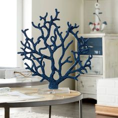 a blue coral sculpture sitting on top of a table in front of a white wall