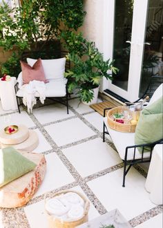 an outdoor patio with white furniture and plants