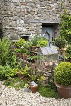 a stone building with potted plants in front of it