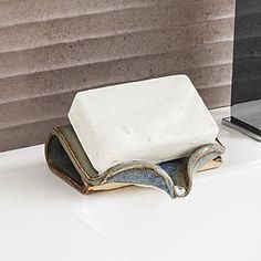 a white and blue ceramic dish sitting on top of a counter next to a mirror