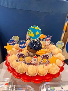 cupcakes are arranged in the shape of a cake with space themed decorations on top