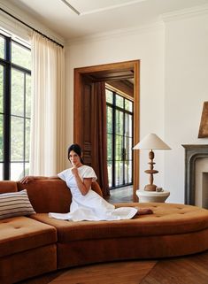 a woman sitting on top of a brown couch