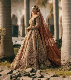 a woman in a bridal gown standing next to some palm trees